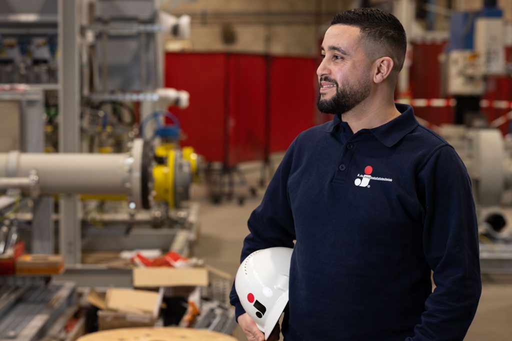 Medewerker van A. de Jong met veiligheidshelm in de werkplaats
