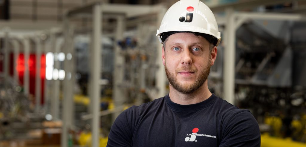 Medewerker van A. de Jong met veiligheidshelm in de werkplaats